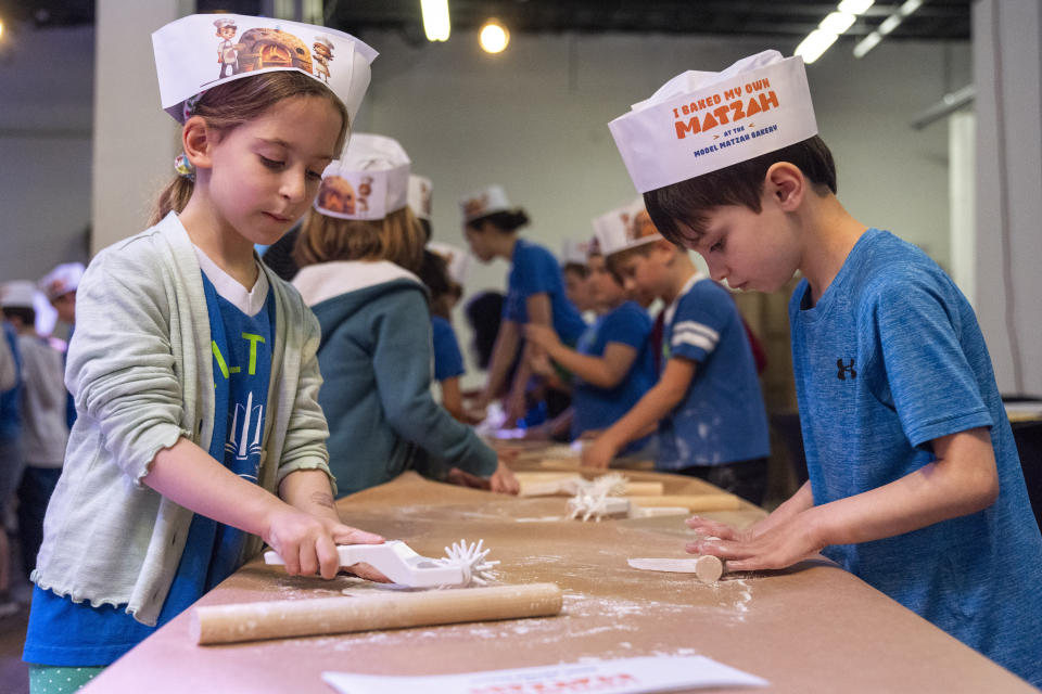 First graders from Milton Gottesman Jewish Day School of the Nation's Capital, make matzah during a "Matzah Factory" field trip to the JCrafts Center for Jewish Life and Tradition in Rockville, Md., Thursday, April 18, 2024, ahead of the Passover holiday which begins next Monday evening. To be kosher for Passover the dough has to be prepared and cooked all within 18 minutes and not allowed to rise. (AP Photo/Jacquelyn Martin)