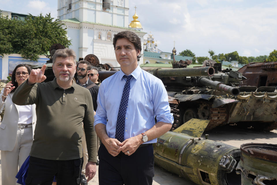 Prime Minister Justin Trudeau, right, is shown burned out Russian tanks by Ukraine Deputy Defense Minister Oleksandr Polishchuk in Kyiv, Ukraine, on Saturday, June 10, 2023. (Frank Gunn/The Canadian Press via AP)