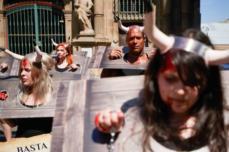 Protesters with their faces smeared in fake blood and chains around their wrists take part in a demonstration against bullfighting, ahead of the San Fermin 2024 festivities. The famous bullfight in Pamplona, ​​northern Spain, began on Saturday despite protests of animal rights activists.  Images by Elsa A Bravo/SOPA via ZUMA Press Wire/dpa