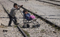 <p>A boy pushes a stroller with a child at the migrants camp in Idomeni, Greece, May 22, 2016. Thousands of stranded refugees and migrants have camped in Idomeni for months after the border was closed. (Darko Bandic/AP) </p>