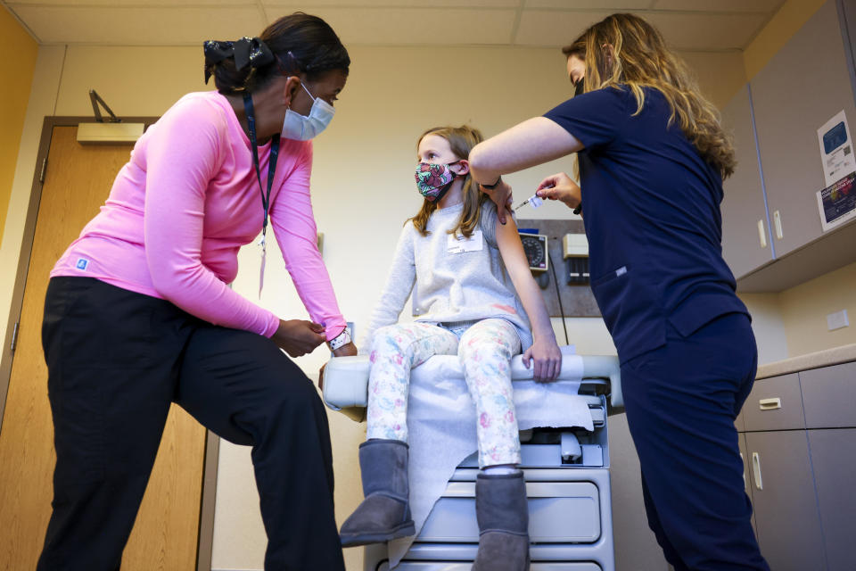 A nurse administers a pediatric COVID vaccine to a 9-year-old.