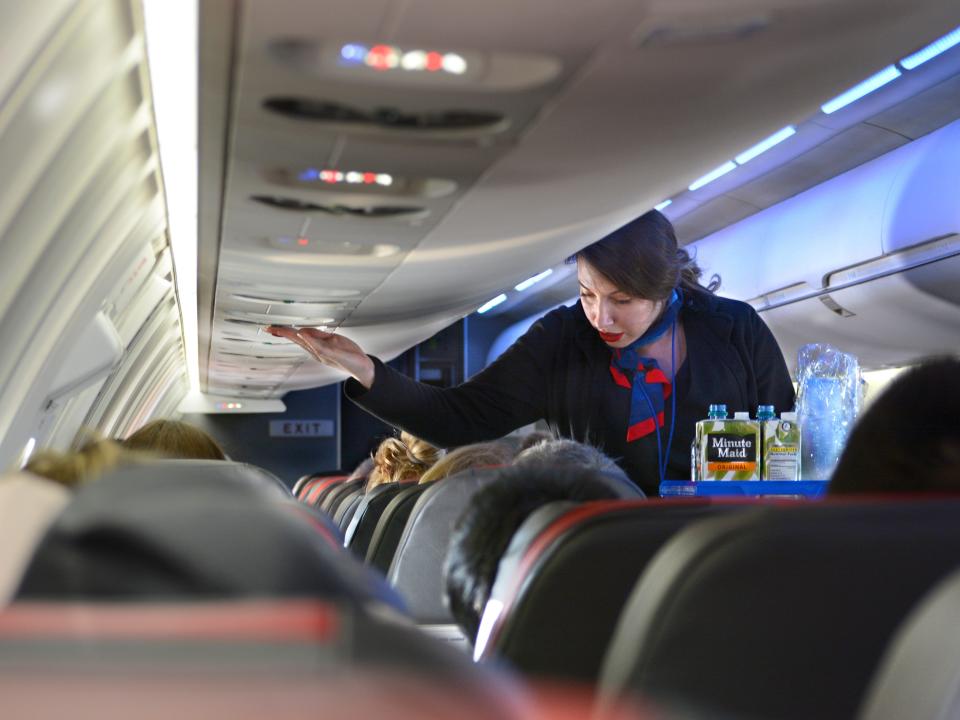 An American Airlines flight attendant serving passengers on a 2018 flight.