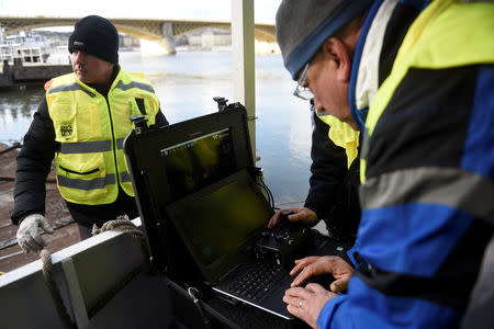 Volunteers of Israeli rescue and recovery organisation ZAKA survey images transmitted by an underwater sonar during a search for the remains of Holocaust victims murdered on the banks of the Danube river in 1944 in Budapest, Hungary January 15, 2019. REUTERS/Tamas Kaszas