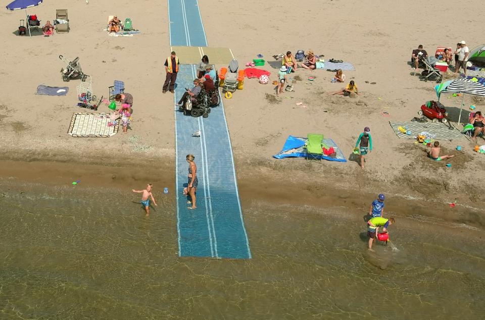 Mobi-mats are mats that can be placed along the beach floor to help people with disabilities reach the water's edge. Pictured is an installation by Watts Accessibility Consulting in Cobourg, Ont.