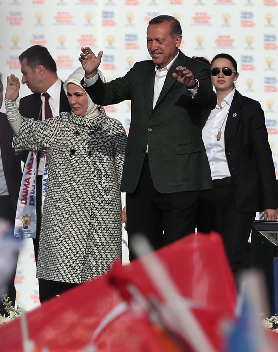 Turkish Prime Minister Recep Tayyip Erdogan, center right, addresses supporters of his Justice and Development Party during a rally in Istanbul, Turkey, Sunday, March 23, 2014. Turkish fighter jets shot down a Syrian warplane after it violated Turkey's airspace Sunday, Erdogan said, in a move likely to ramp up tensions between the two countries already deeply at odds over Syria's civil war. Erdogan is fighting corruption allegations against his government a week before local elections that are seen as a referendum over his rule. His wife Emine Erdogan stands at the left(AP Photo/Emrah Gurel)