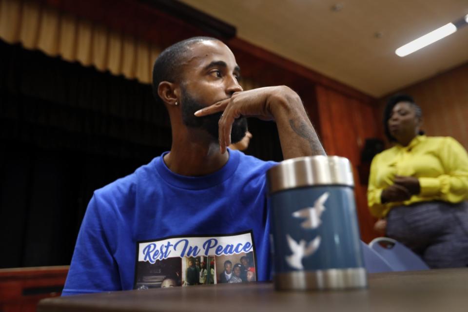 Cory McLean with a cup of Gemmel Moore's ashes.