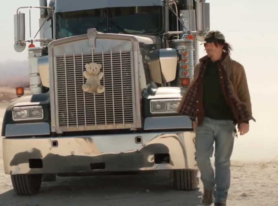 A man standing next to a big rig truck