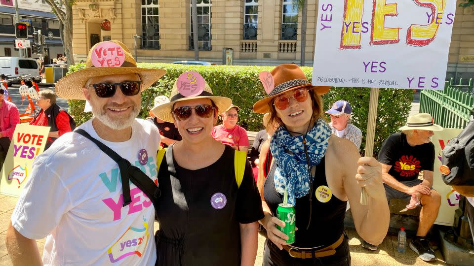 Erin Johnston (center) with friends Michael Blair (left) and Andy Roache (right) at a Yes rally in Brisbane on Sunday, September 17, 2023. - Hilary Whiteman/CNN