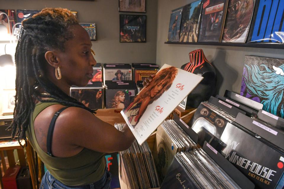 Nadine Walker, of Port St. Lucie, browses the collection of records for sale at Vintage Vibe 420, a record and art store at 420 Colorado Ave. on Saturday, April 13, 2024, in downtown Stuart. “I like that I could pick up the needle and move it. It just brings me back to being young and a child and having that in my house,” Walker said. “I guess it’s just the aesthetic of it, just being able to pick up and move that needle to where I want it to go instead of pressing a button and skipping to the next song. I sort of like the sounds it makes too, as it plays. That air sound as it goes over on the record. Those are my favorite thing about records.”