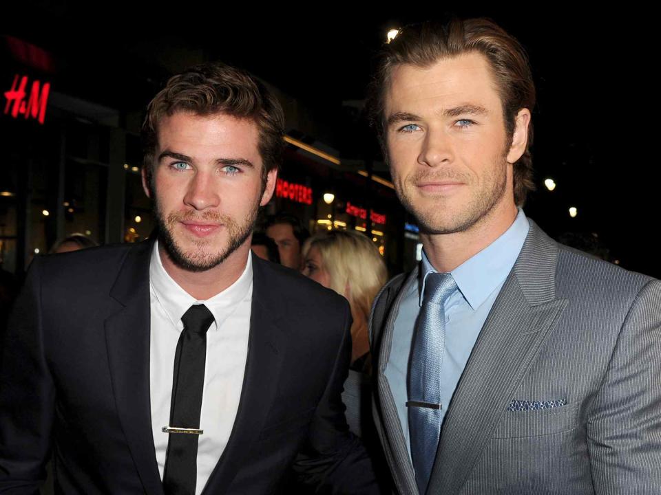 <p>Kevin Winter/Getty</p> Liam Hemsworth and Chris Hemsworth on November 4, 2013