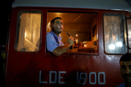 Engine driver smokes shisha after arriving to recently opened international fair in Damascus, Syria, September 12, 2018. REUTERS/Marko Djurica