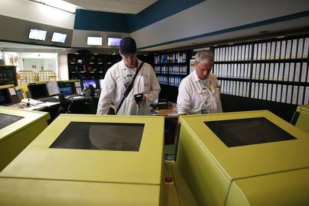 Employees work in the operation room of Areva Nuclear Plant for the treatment of nuclear waste at La Hague, near Cherbourg, western France, April 22, 2015. REUTERS/Benoit Tessier