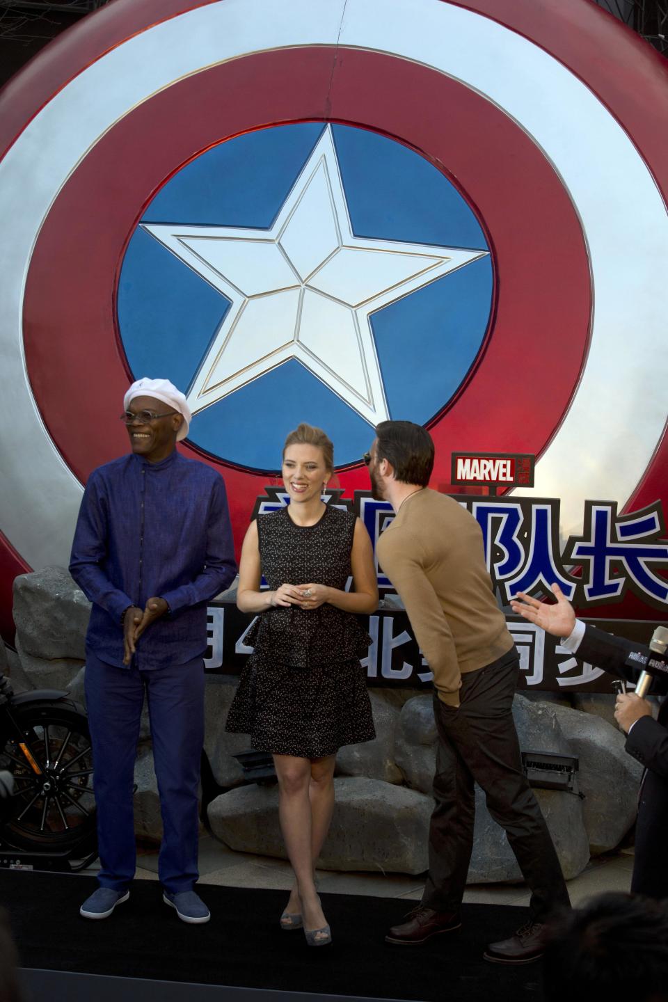 In this Monday, March 24, 2014 photo, actress Scarlett Johansson stands between Samuel L. Jackson, left, and Chris Evans during a publicity event ahead of the April release of their movie "Captain America: The Winter Soldier" in Beijing. Captain America and Spiderman are seeking to dominate the Chinese box office in the coming weeks, proving that U.S. patriotic superheroes can overcome China’s leeriness of foreign films if they promise big money. Chinese authorities, wary of outside cultural influences and competition, restrict the number of foreign movies shown in the mainland’s cinemas to 34 each year. (AP Photo/Ng Han Guan)