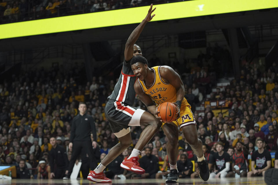 Minnesota forward Pharrel Payne, right, works toward the basket as Ohio State center Felix Okpara, center left, defends during the first half of an NCAA college basketball game Thursday, Feb. 22, 2024, in Minneapolis. (AP Photo/Abbie Parr)