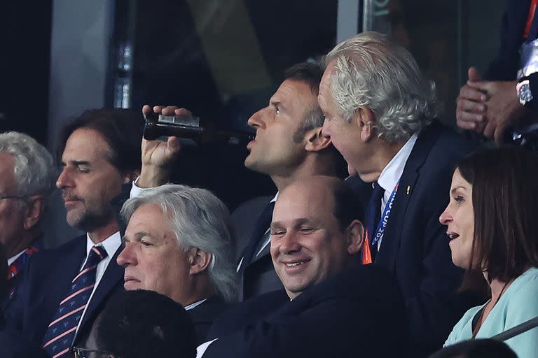 Emmanuel Macron bebe una cerveza durante le partido Francia-Uruguay; a su derecha, el presidente de Uruguay, Luis Lacalle Pou