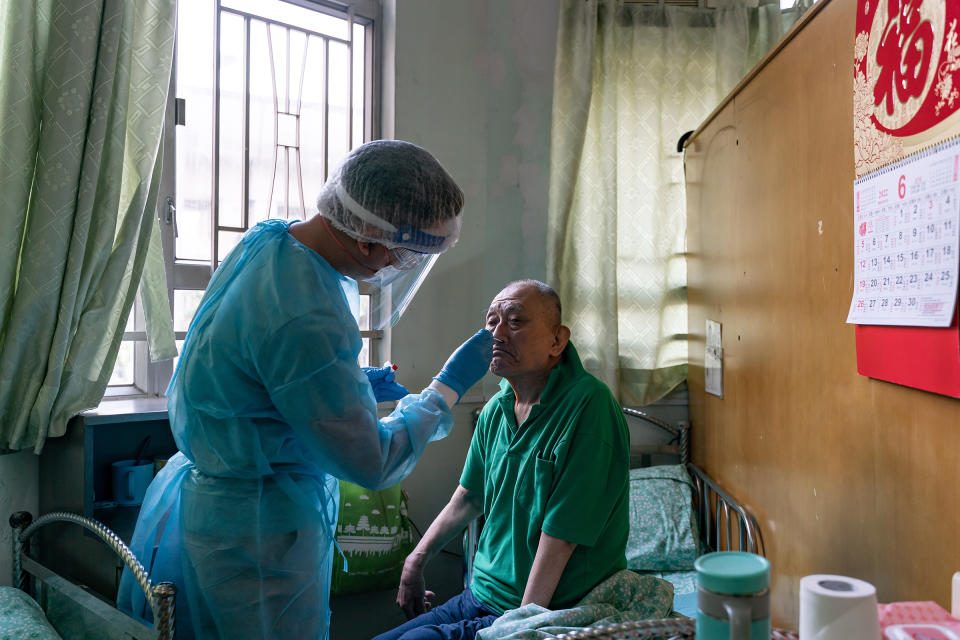 Dr. Poon Yui Pan, deputy head of Hong Kong's Kei Tak (Tai Hang) Home for the Aged, conducts a rapid antigen test on a resident.<span class="copyright">Anthony Kwan for TIME</span>