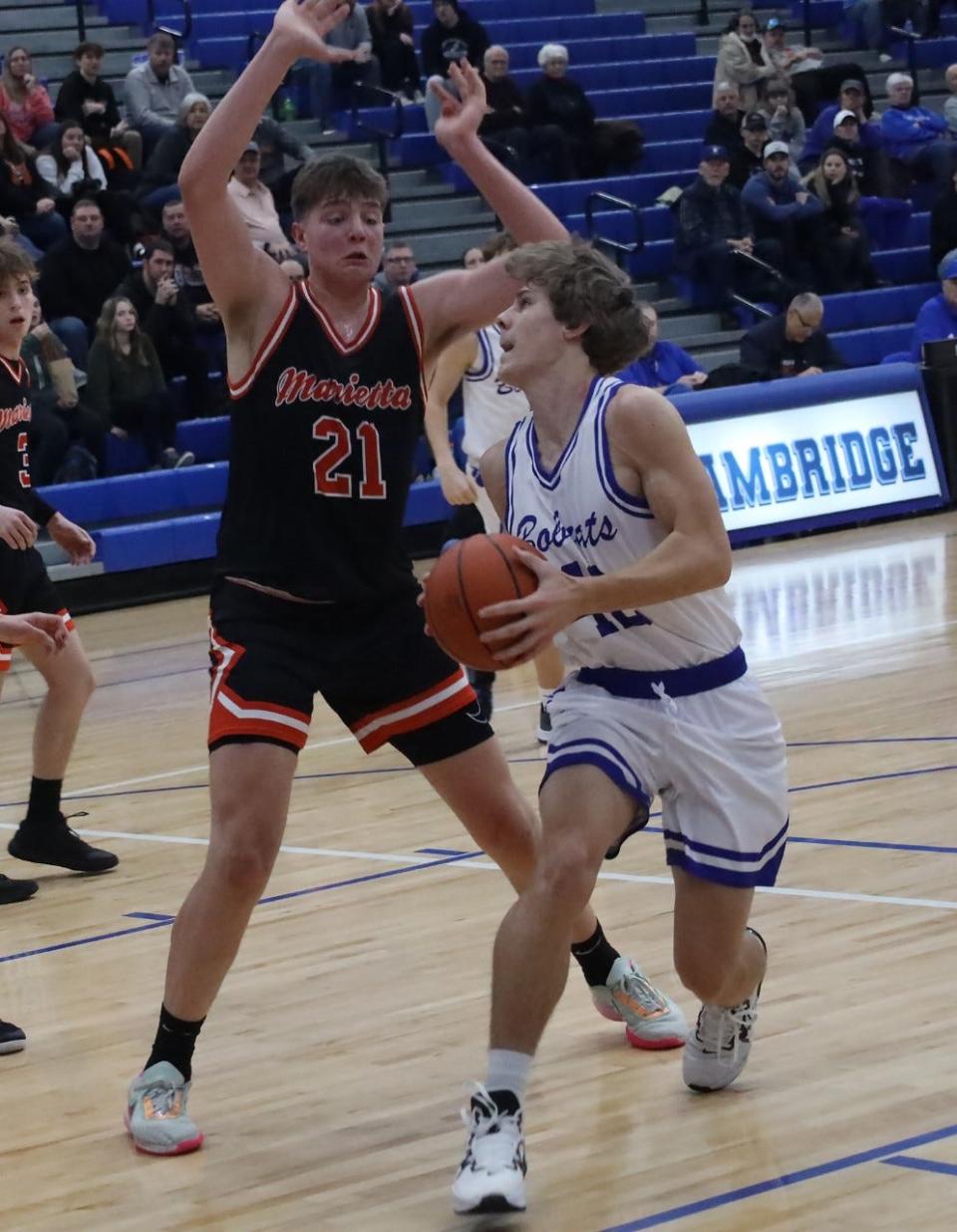 Cambridge junior Devin Ogle (42) looks to make a move on Marietta's 6-7 Alex Kendall during Friday's non-league action inside Gene Ford Gymnasium.