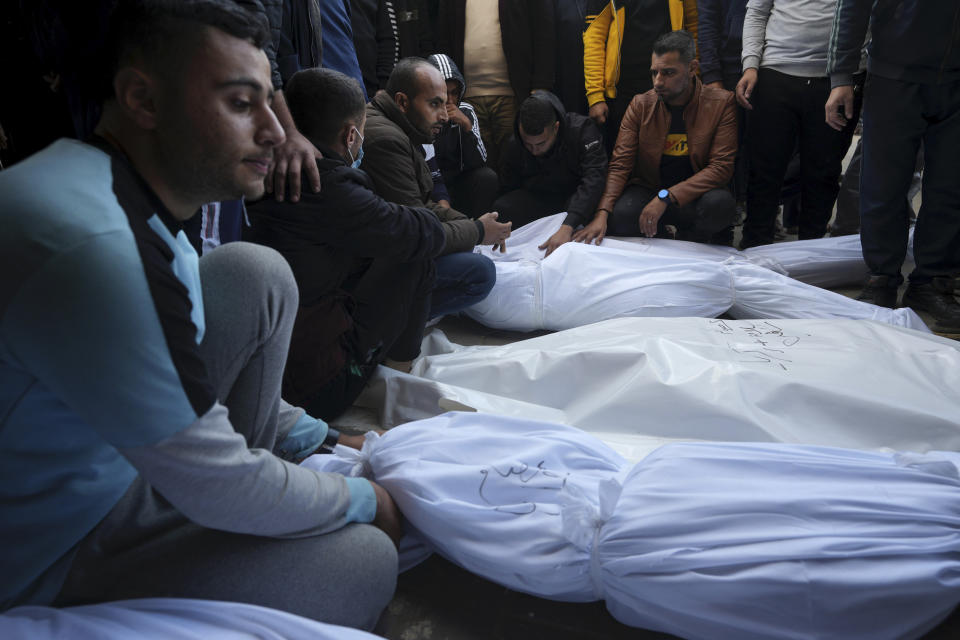 Palestinians mourn their relatives killed in the Israeli bombardment of the Gaza Strip in Deir al Balah on Wednesday, Dec. 20, 2023. (AP Photo/Adel Hana)