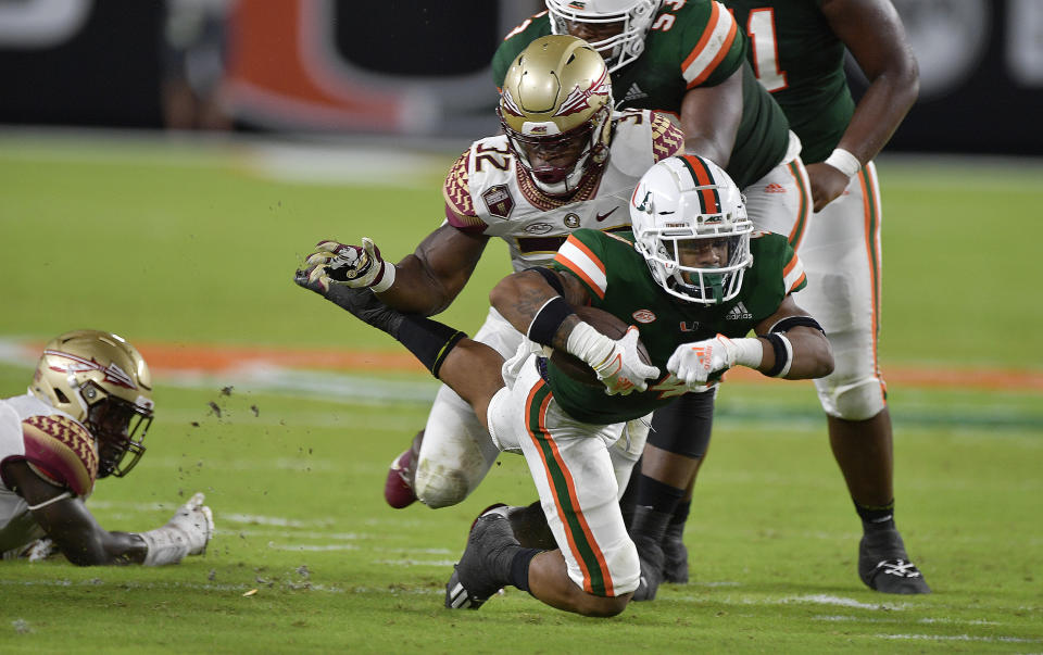 Miami running back Jaylan Knighton dives for an extra yard against Florida State linebacker Stephen Dix, Jr. during the first half of an NCAA college football game, Saturday, Sept. 26, 2020, in Miami Gardens, Fla. (Michael Laughlin/South Florida Sun-Sentinel via AP)