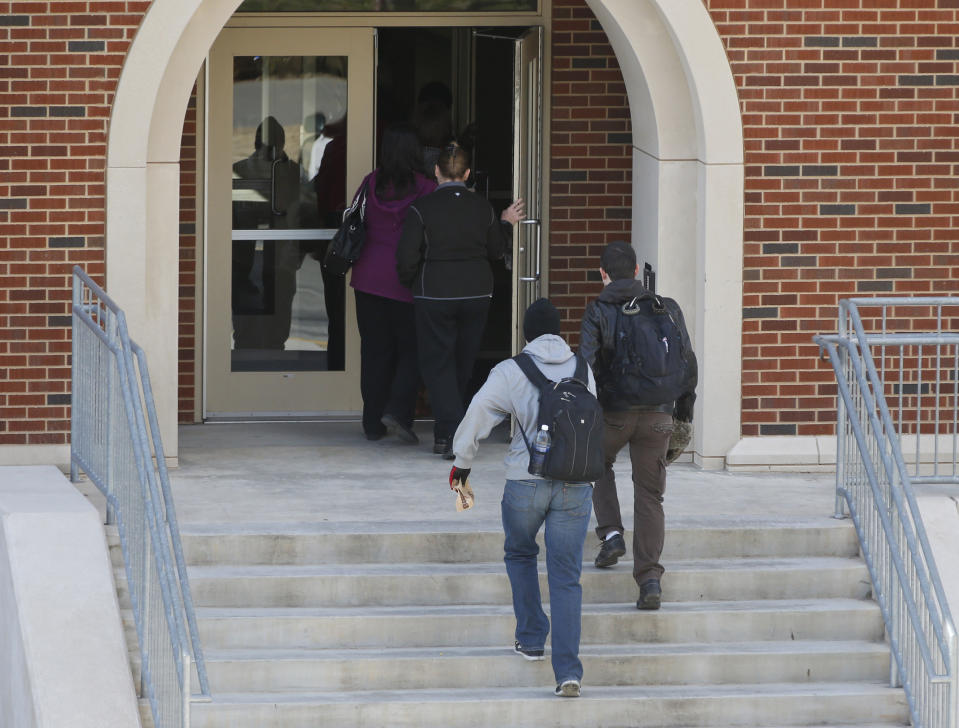 People enter Gould Hall at the University of Oklahoma in Norman, Okla., Wednesday, Jan. 22, 2014, after the area was re-opened. The area had been closed down following reports of gunfire. (AP Photo/Sue Ogrocki)