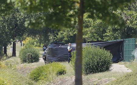 A French Gendarme stands guard next to a black plastic sheet outside a gas company site at the industrial area of Saint-Quentin-Fallavier, near Lyon, France, June 26, 2015. REUTERS/Emmanuel Foudrot