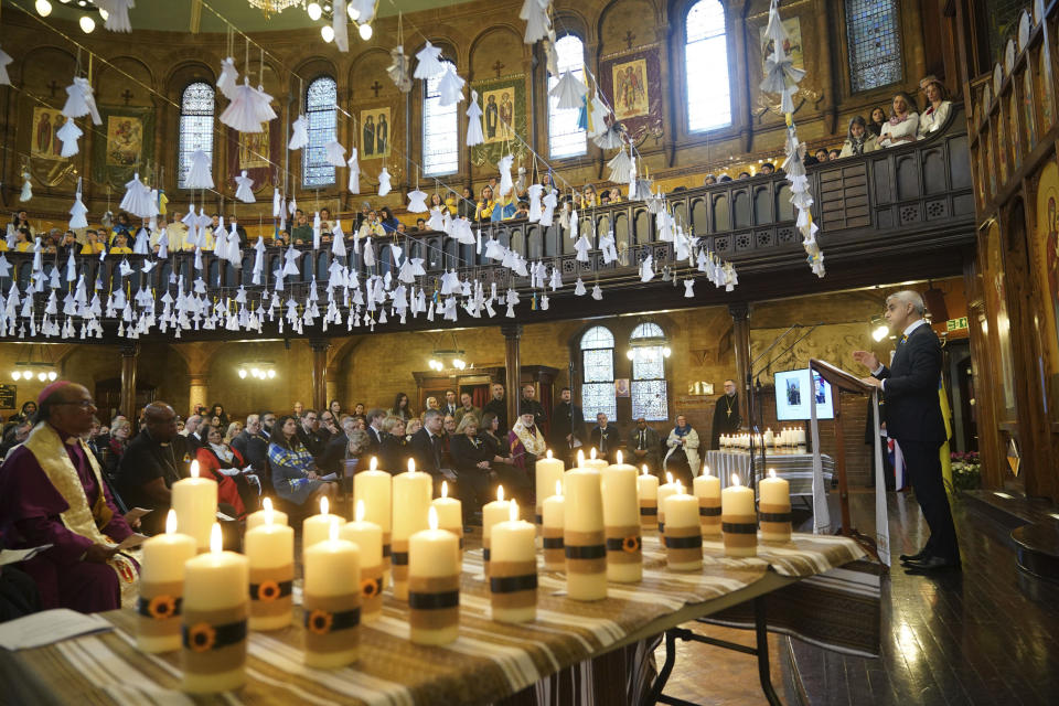52 candles, one for each week of the war, beneath 461 paper angels, one for each child that has died in the past year according to the official statistics, as Mayor of London Sadiq Khan, right, speaks during an ecumenical prayer service at the Ukrainian Catholic Cathedral in London, Britain, to mark the one year anniversary of the Russian invasion of Ukraine, Friday Feb. 24, 2023. (Yui Mok/PA via AP)