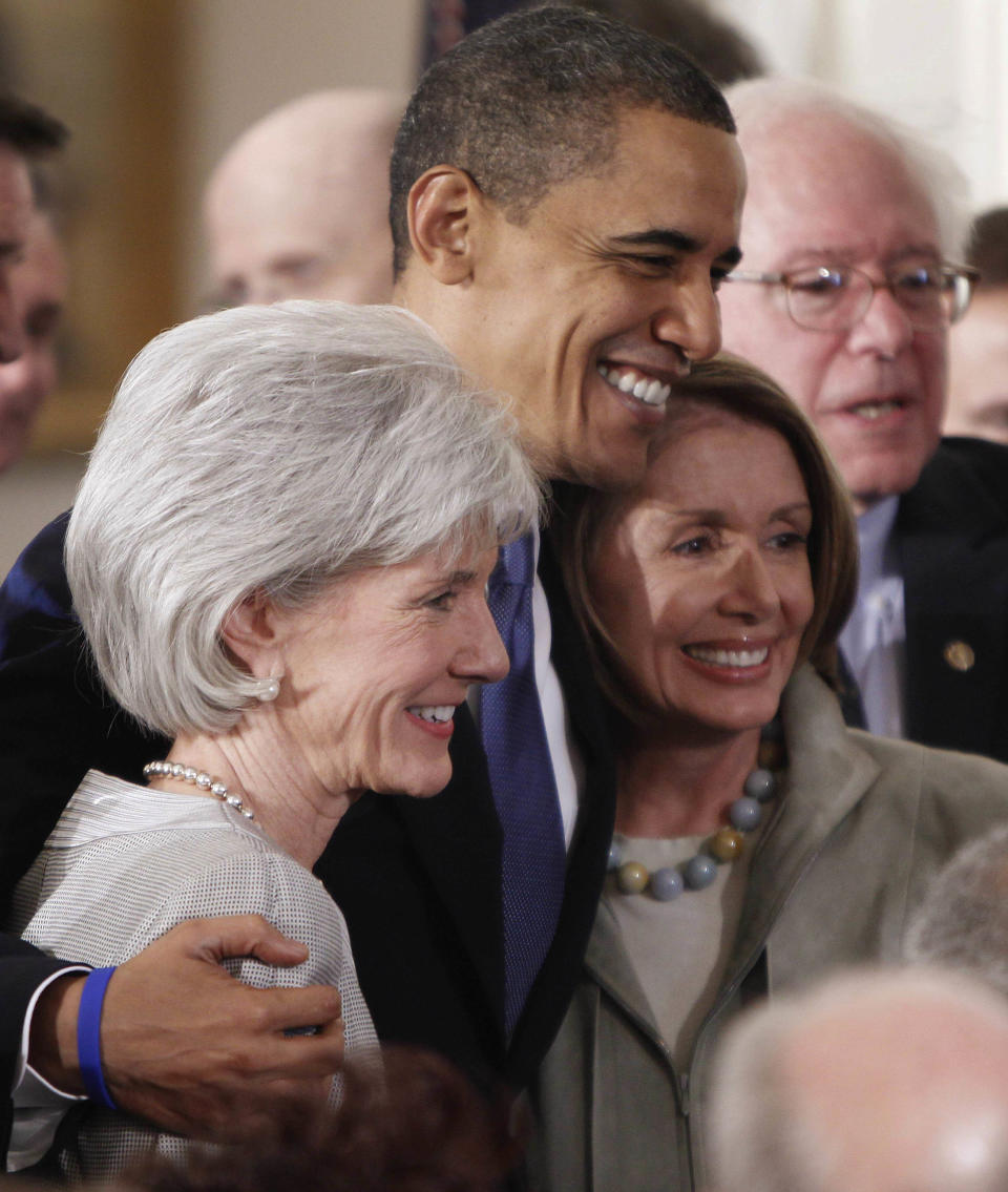 FILE - In a March 23, 2010, file photo President Barack Obama embraces Health and Human Services Secretary Kathleen Sebelius, left, and House Speaker Nancy Pelosi of Calif. in the East Room of the White House in Washington after he signed the health care bill. Obama and Pelosi devoted a vast amount of his first term to passing a health care law that has divided the nation. By winning at the Supreme Court, Obama and his party preserve historic legislation, that liberals have been pining for for more than 50 years. (AP Photo/Charles Dharapak, File)