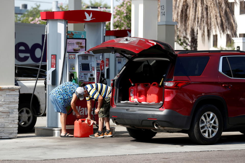 A couple fills up multiple 5 gallon gas tanks at a Wawa gas station, after a cyberattack crippled the biggest fuel pipeline in the country, run by Colonial Pipeline, in Tampa, Florida on May 12, 2021. (Octavio Jones/Reuters)