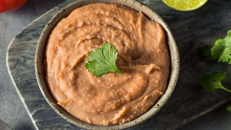 bowl of refried beans, cilantro, lime
