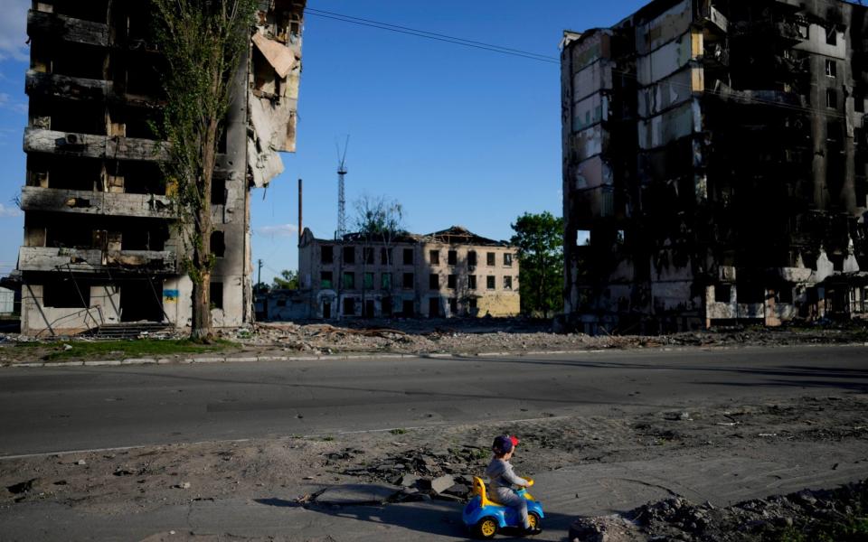 A boy plays in front of houses ruined by shelling in Borodyanka - Natacha Pisarenko /AP