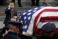<p>Ryan Lemm, 4, salutes as he is carried by New York Police Department officer John McCrossen as he watches the casket of his father, NYPD officer Joseph Lemm, who was killed on duty in Afghanistan, following funeral services in the Manhattan borough of New York, Dec. 30, 2015. McCrossen was Lemm’s partner in the NYPD Warrant Squad. Lemm was one of six U.S. troops killed by a suicide bomber near Bagram air base in Afghanistan. (Photo: Carlo Allegri/Reuters) </p>