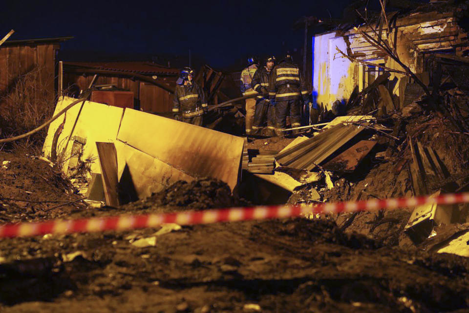 Firefighters work at the scene after a warplane crashed into a residential area in Irkutsk, Russia, Sunday, Oct. 23, 2022. A Russian warplane slammed into a residential building in the Siberian city of Irkutsk Sunday, killing both crewmembers — the second incident in less than a week in which a combat jet has crashed in a residential area. (AP Photo)