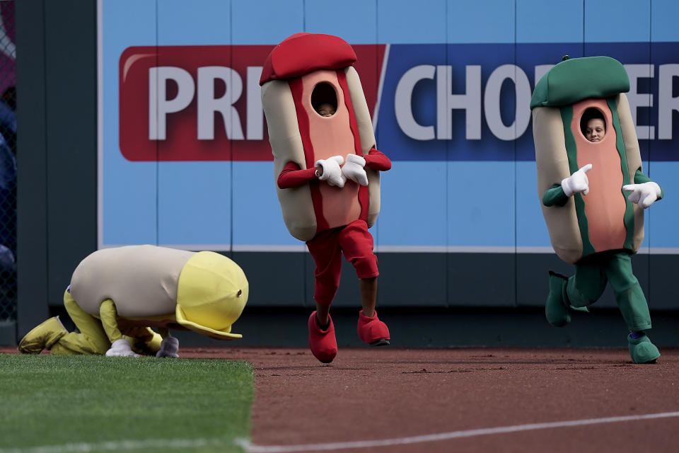 Youngsters dressed as hot dogs compete in the hot dog derby during a baseball game between the Kansas City Royals and the Detroit Tigers Sunday, Sept. 11, 2022, in Kansas City, Mo. (AP Photo/Charlie Riedel)