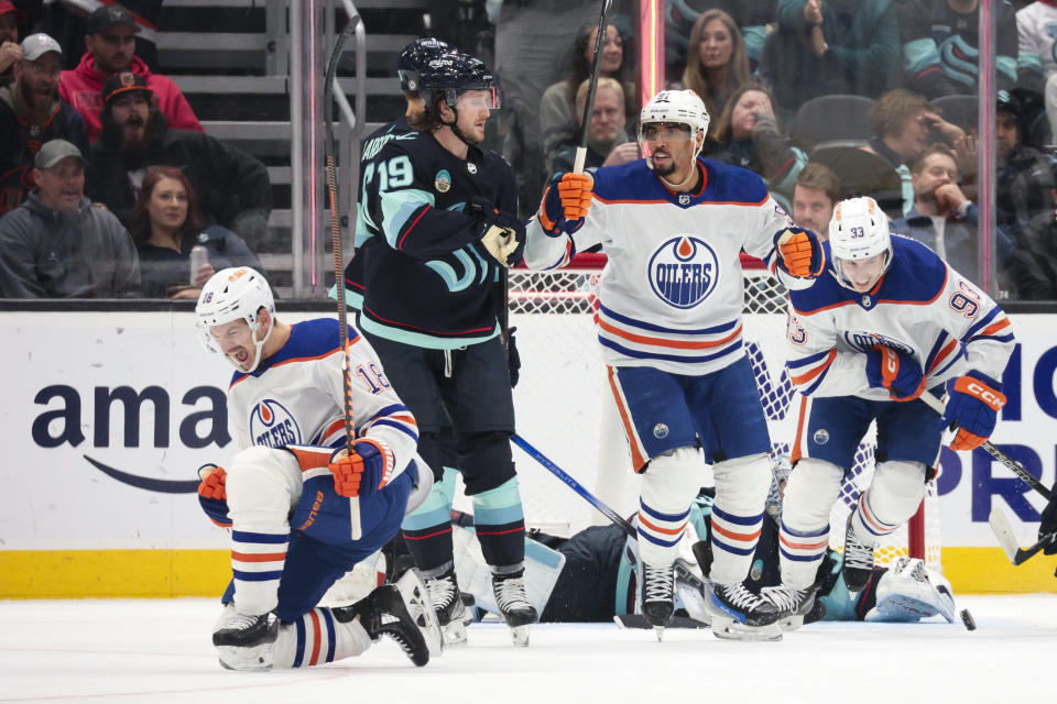 Edmonton Oilers left wing Zach Hyman, left, celebrates his hat trick, next to Seattle Kraken left wing Jared McCann (19) during the first period of an NHL hockey game Saturday, Nov. 11, 2023, in Seattle. (AP Photo/Jason Redmond)