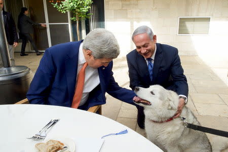 Israeli Prime Minister Benjamin Netanyahu (R) shows U.S. Secretary of State John Kerry his recently adopted dog Kaiya, during their meeting in Jerusalem November 24, 2015. REUTERS/State Department Photo/Public Domain/Handout via Flicker