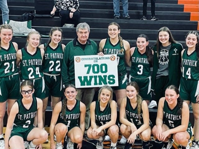 The Portland St. Patrick girls basketball team poses for a picture with coach Al Schrauben after giving him his 700th career win on Thursday, Jan. 19, 2023, at Morrice. The Shamrocks defeated Morrice, 64-27.