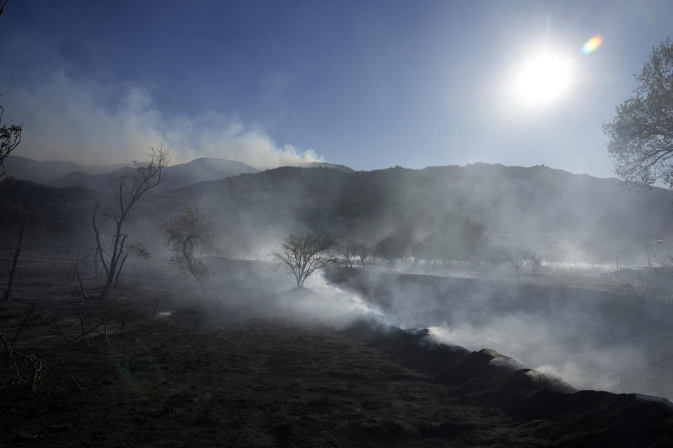 A field and hills smolder after the Highland Fire passed through, Tuesday, Oct. 31, 2023, in Aguanga, Calif. (AP Photo/Marcio Jose Sanchez)