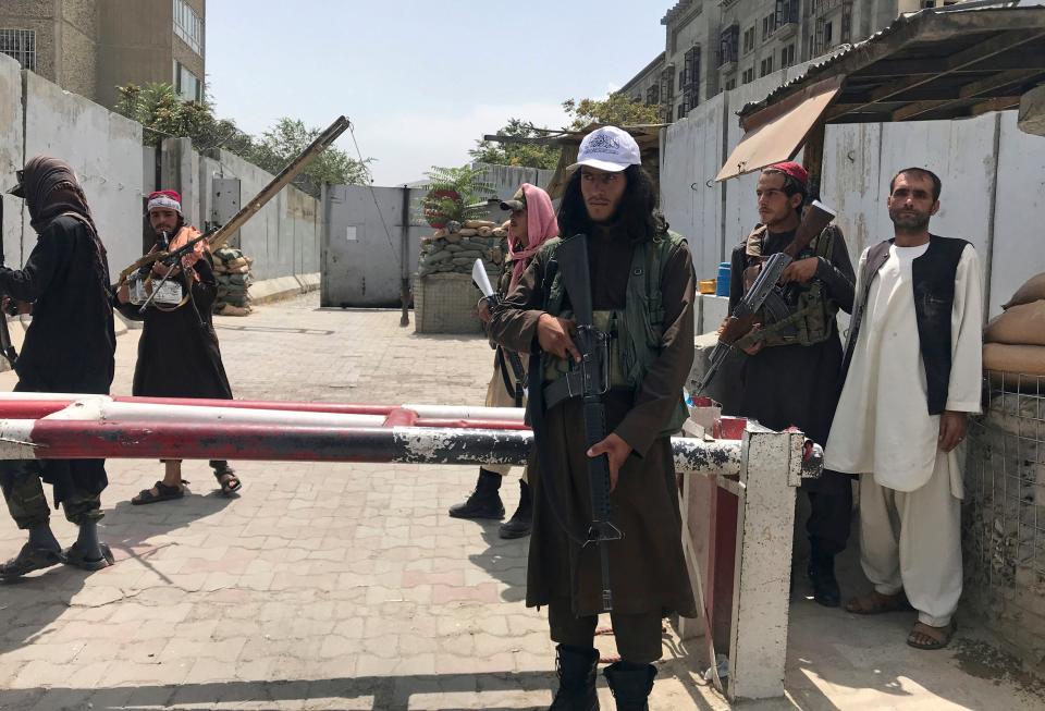 Taliban fighters stand guard at a checkpoint near the U..S embassy that was previously manned by American troops, in Kabul, Afghanistan, Aug. 17, 2021. A new report says decisions by Presidents Donald Trump and Joe Biden to pull all U.S. troops out of Afghanistan were the key factors in the collapse of that nation's military, leading to the Taliban takeover last year. (AP Photo, File)