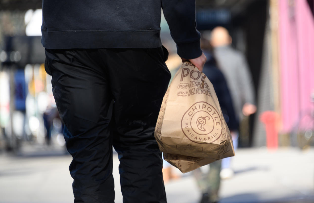 NEW YORK, NEW YORK - DECEMBER 11: A person carries a take out bag outside Chipotle on the Upper West Side on December 11, 2020 in New York City.  Governor Andrew Cuomo announced that indoor dining would close on Monday December 14th due to an ongoing spike in COIVD-19 cases. (Photo by Noam Galai/Getty Images)