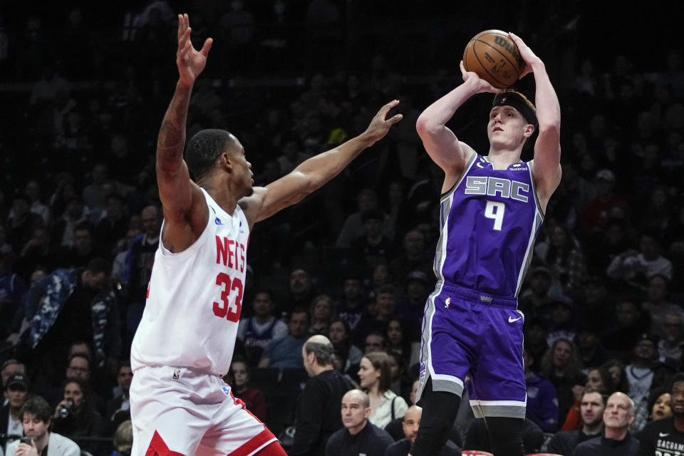 Sacramento Kings' Kevin Huerter (9) shoots over Brooklyn Nets' Nic Claxton (33) during the first half of an NBA basketball game Thursday, March 16, 2023, in New York. (AP Photo/Frank Franklin II)