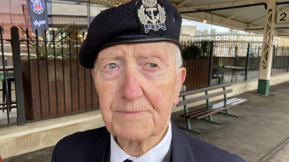 Stan Ford on the platform of Bath Railway station. He is wearing his cap and jacket with war medals