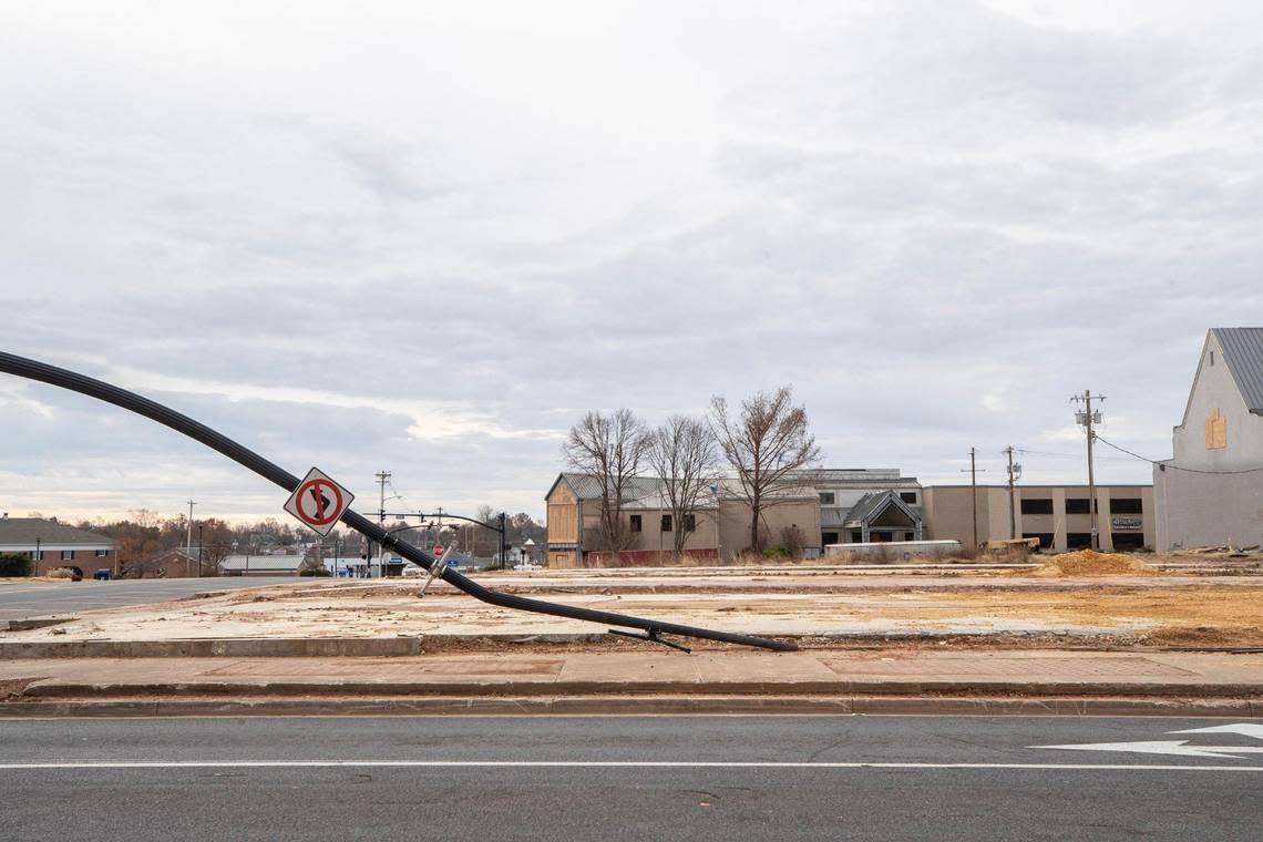 A bent traffic signal pole and an empty slab are all that remain on the corner of West Broadway and South Seventh Street in Mayfield, Ky., a year after a tornado. Sunday, Dec. 4, 2022