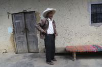 Ireño Castillo, the father of Free Peru party presidential candidate Pedro Castillo, stands inside his home in Puna, Peru, Friday, April 16, 2021. Ireño's rural teacher son, who has proposed rewriting Peru's constitution and deporting all immigrants living in the country illegally who commit crimes, will face rival candidate Keiko Fujimori in the June 6 presidential run-off election. (AP Photo/Martin Mejia)