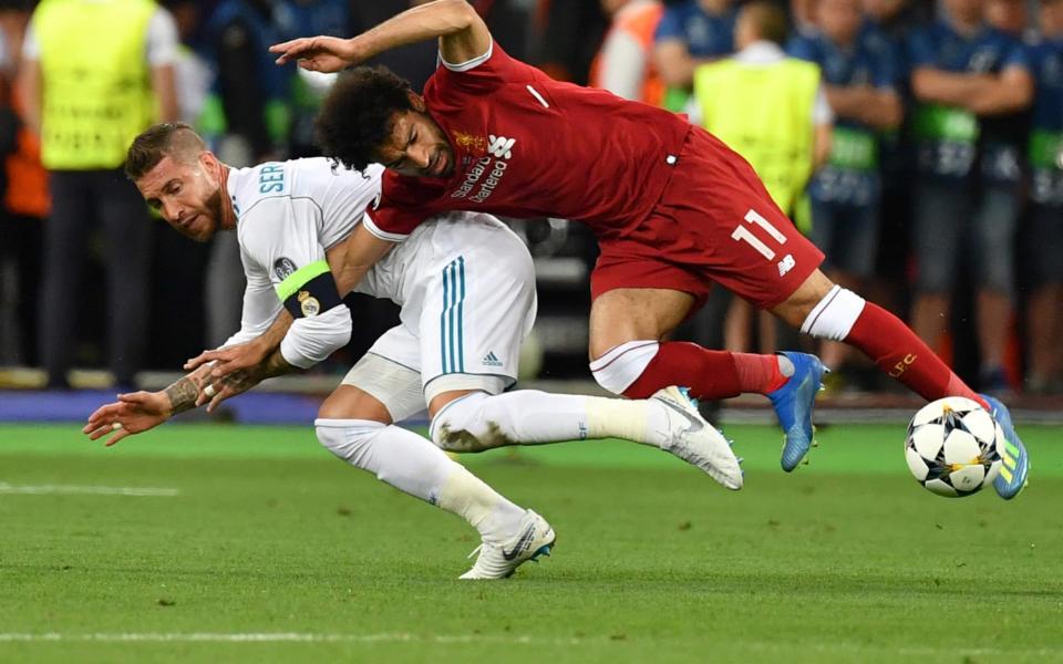 Sergio Ramos grappled with Mo Salah as the Liverpool forward fell to the ground and injured his shoulder during the Champions League final - AFP