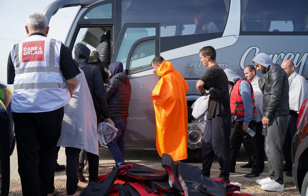A group of people thought to be migrants are escorted on to a bus in Dungeness, Kent, after being intercepted by the Dungeness Lifeboat (Gareth Fuller/PA) (PA Wire)