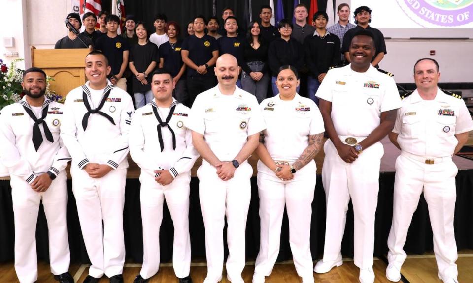 Merced Union High School District seniors set to enlist in the Navy pose for photos with active members during a luncheon at Merced High School on Tuesday, May 21, 2024.
