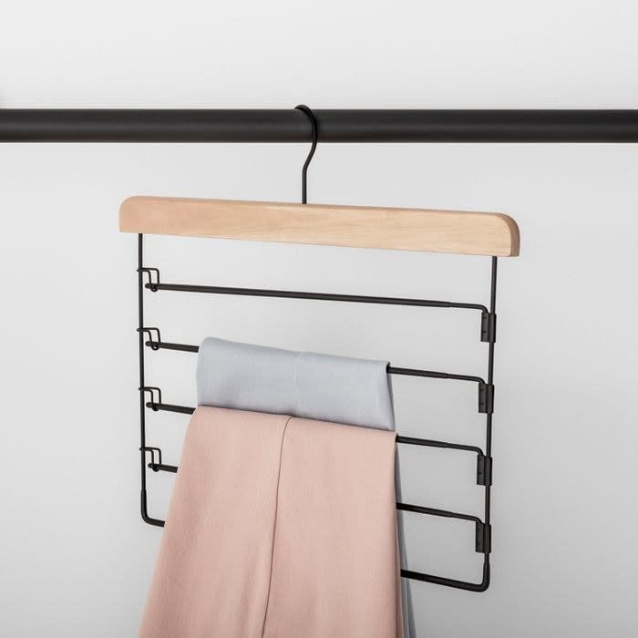 black pants hanger holding up a pink pant and a light gray pant