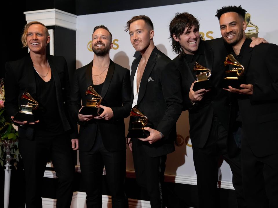 The band Rüfüs Du Sol posing with Grammy awards at the 2022 Grammys.