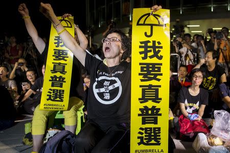 Pro-democracy protesters shout while holding banners which read "I want real universal suffrage" during a demonstration outside Legislative Council in Hong Kong, China June 17, 2015. REUTERS/Tyrone Siu