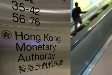 FILE PHOTO: A security guard walks past a directory board of Hong Kong Monetary Authority (HKMA) in Hong Kong December 20, 2012. REUTERS/Tyrone Siu